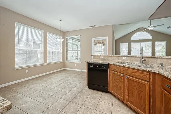 a large kitchen with granite countertop a sink and a stove