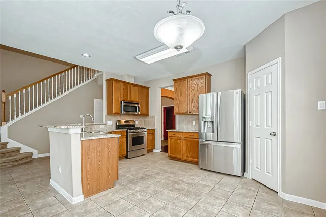 a kitchen with stainless steel appliances granite countertop a refrigerator oven a stove top oven and a refrigerator