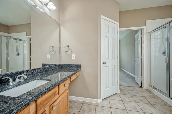 a bathroom with a granite countertop sink and a mirror