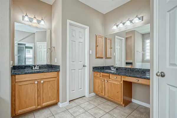 a spacious bathroom with a granite countertop sink a mirror and a shower