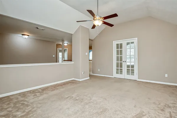 an empty room with windows and fan