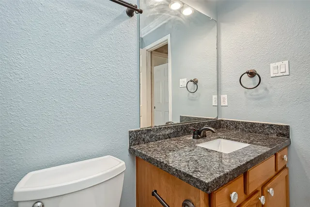 a bathroom with a granite countertop sink and a mirror