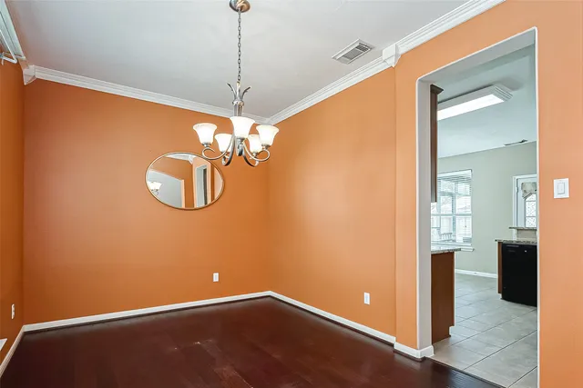 a view of a room with a hanging light and kitchen