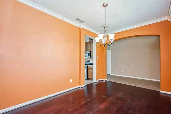an empty room with wooden floor fan and window