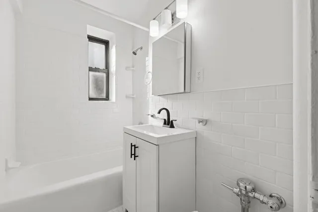 a room with a bed and a refrigerator