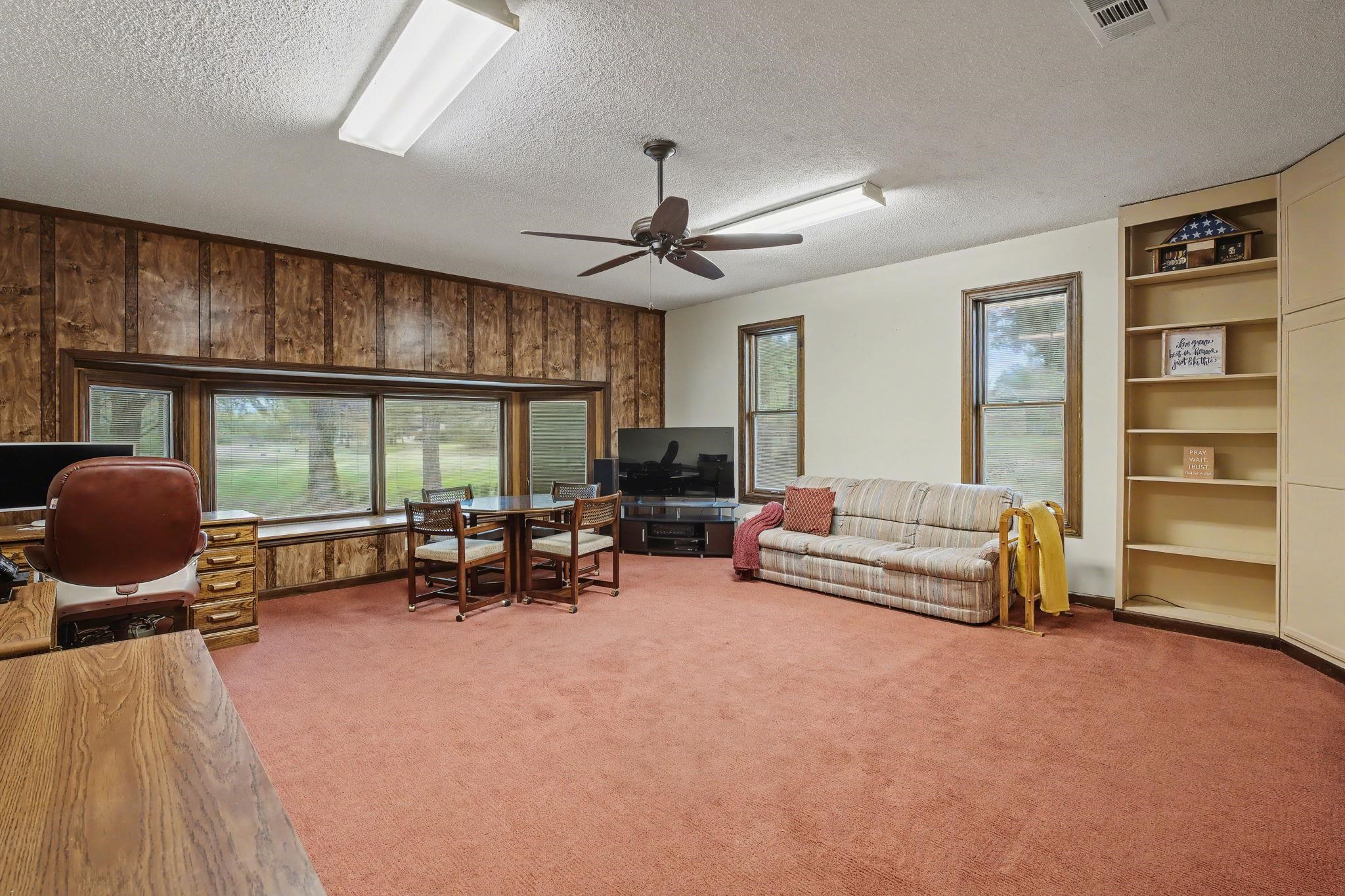 11380 Sycamore Farms Road Collierville, TN 38017 - Photo 18 of 35 Living area featuring wooden walls, light colored carpet, a textured ceiling, a ceiling fan, and built in features