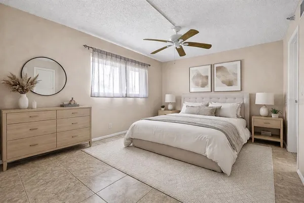 a bedroom with a large bed and a chandelier