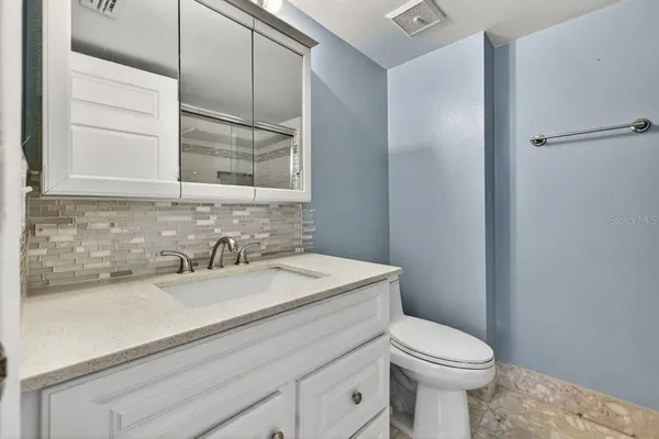 a bathroom with a sink a toilet and mirror