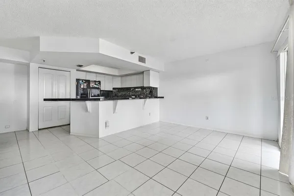 a view of a kitchen with refrigerator and cabinets