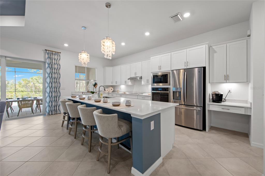 7161 Inlet Isles Lakewood Ranch, FL 34202 - Photo 9 of 29 a kitchen with a center island a sink stainless steel appliances and cabinets