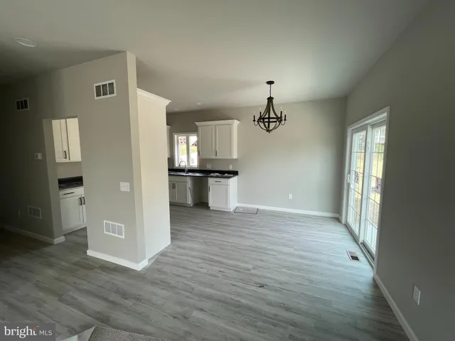 a view of a kitchen with wooden floor and a refrigerator