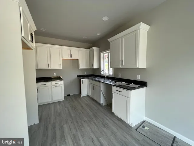 a kitchen with granite countertop white cabinets and white appliances