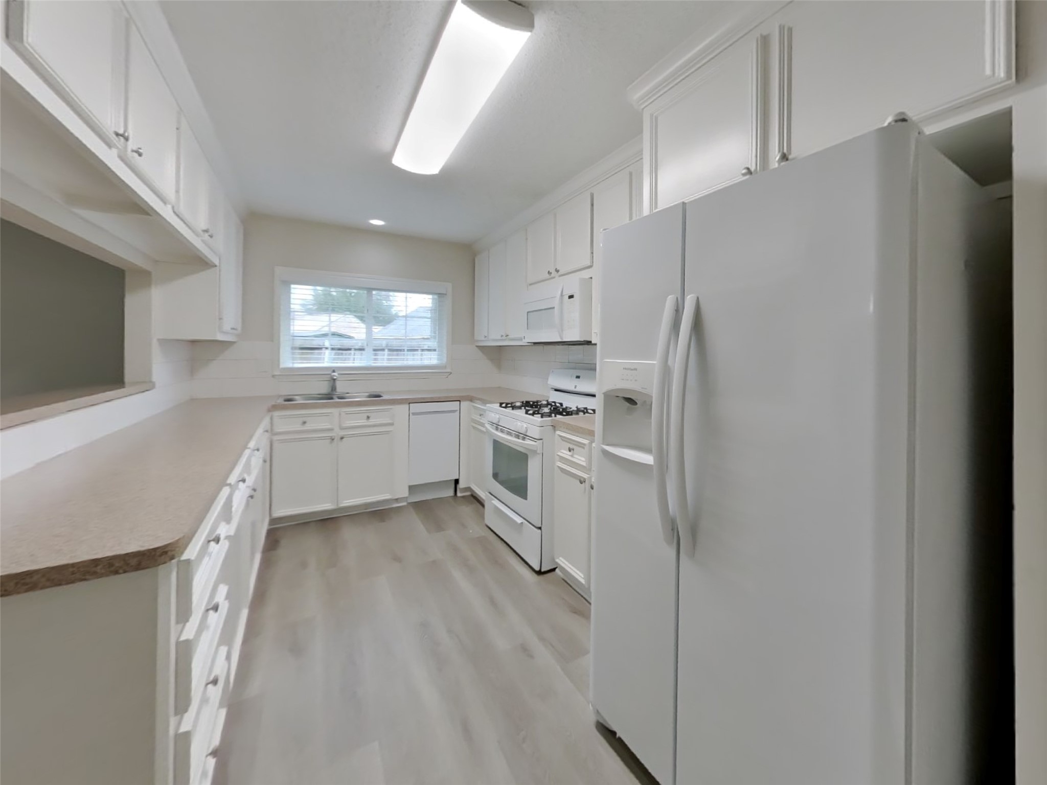 9607 Cleveland Bay Court Houston, TX 77065 - Photo 7 of 18 a kitchen with white cabinets and white appliances