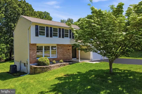 a front view of a house with a yard and trees