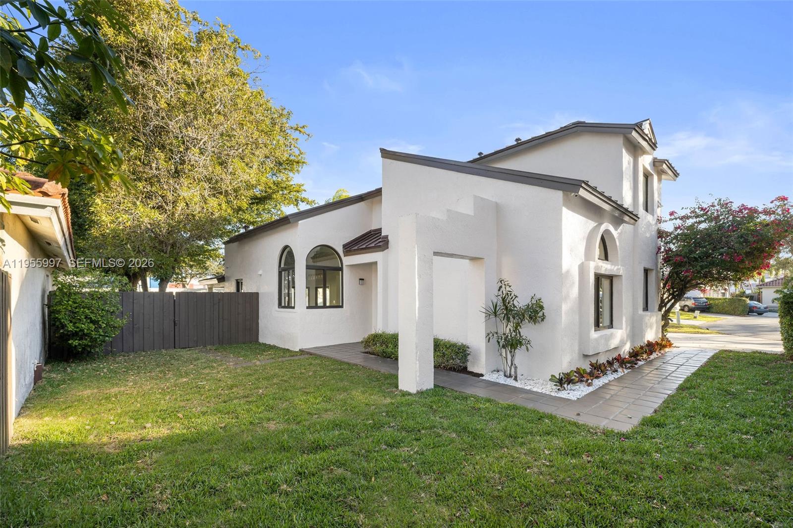 11260 Southwest 157th Court Miami, FL 33196 - Photo 4 of 29 a view of a white house next to a yard with big trees