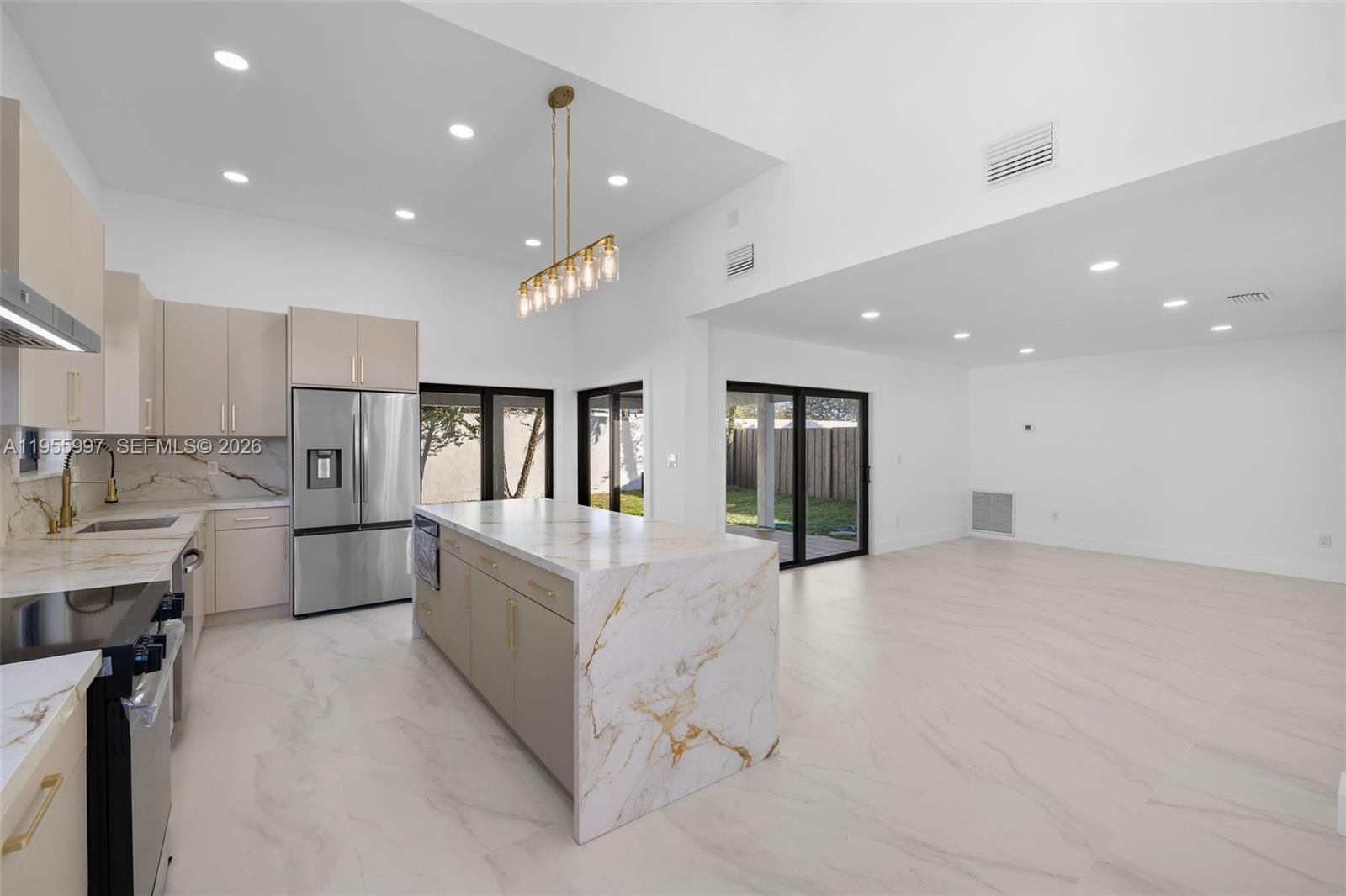 11260 Southwest 157th Court Miami, FL 33196 - Photo 8 of 29 a large white kitchen with kitchen island a sink stainless steel appliances and cabinets