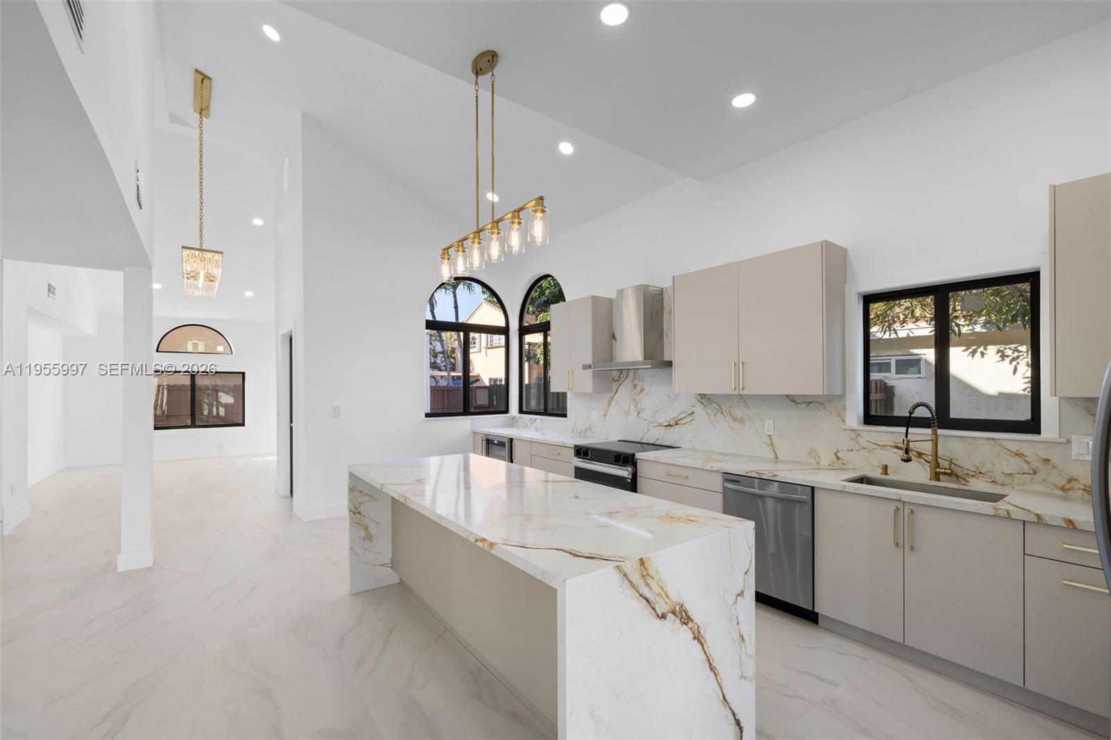11260 Southwest 157th Court Miami, FL 33196 - Photo 9 of 29 a large white kitchen with a sink a window and stainless steel appliances