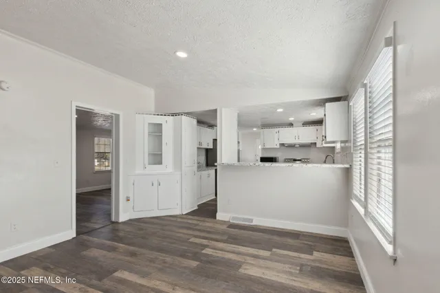 a view of a kitchen with refrigerator and window