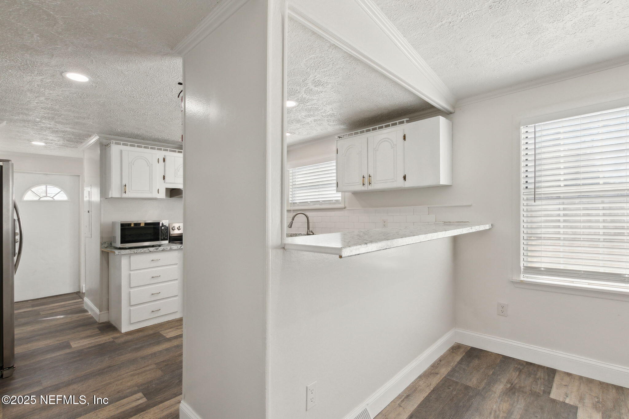 97119 Diamond Street Yulee, FL 32097 - Photo 16 of 42 a kitchen with a refrigerator a stove top oven and white cabinets