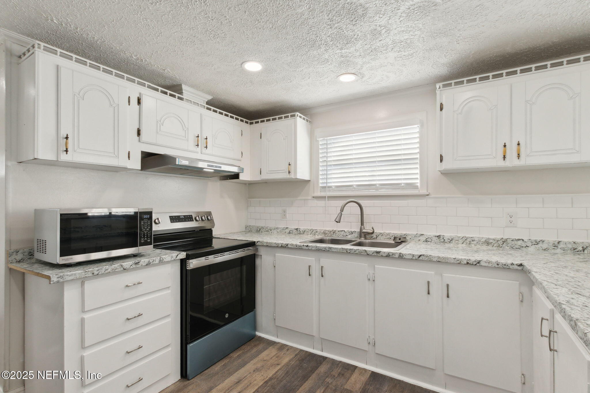 97119 Diamond Street Yulee, FL 32097 - Photo 19 of 42 a kitchen with cabinets appliances a sink and a window