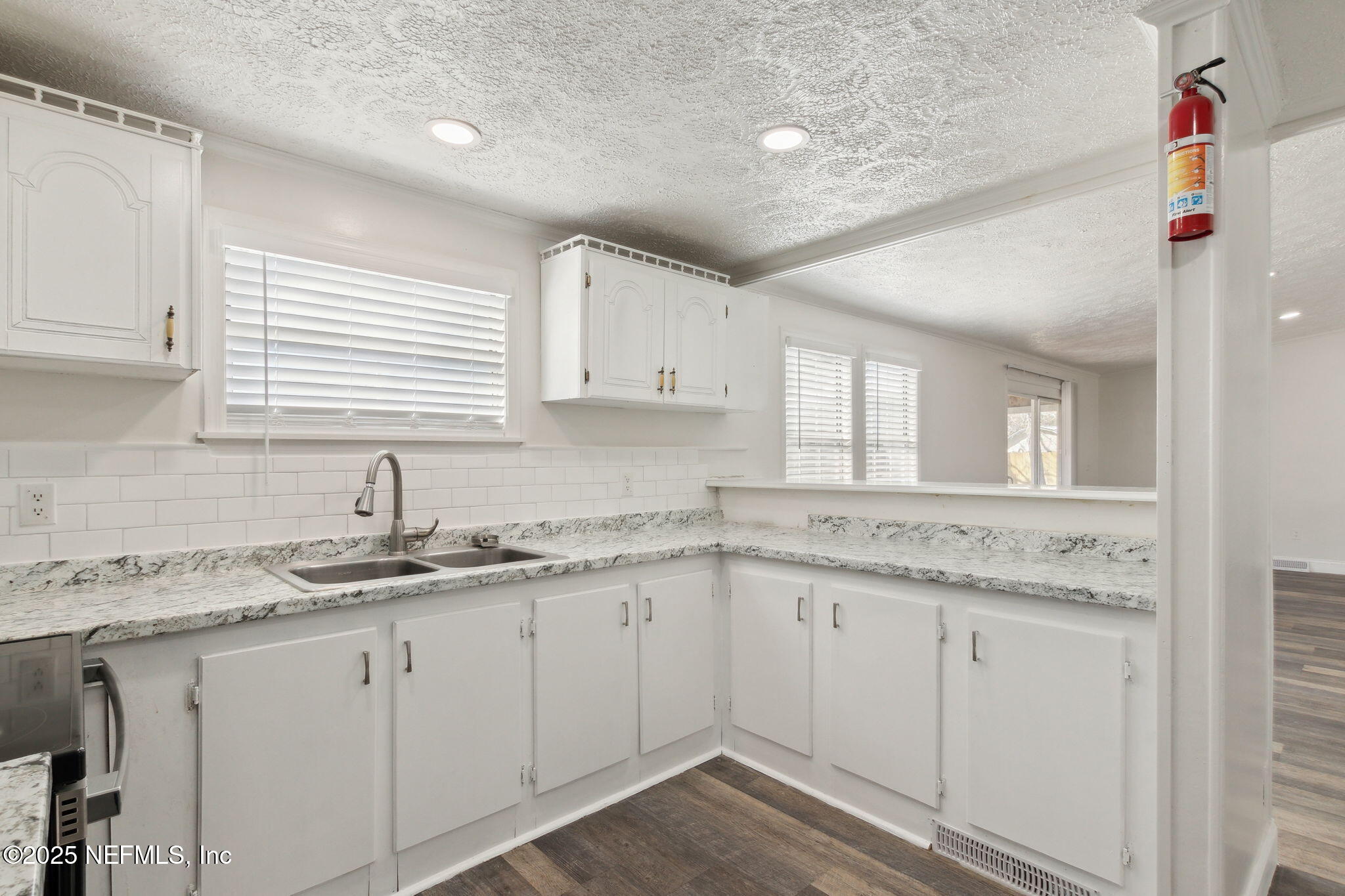 97119 Diamond Street Yulee, FL 32097 - Photo 20 of 42 a kitchen with granite countertop white cabinets and white appliances
