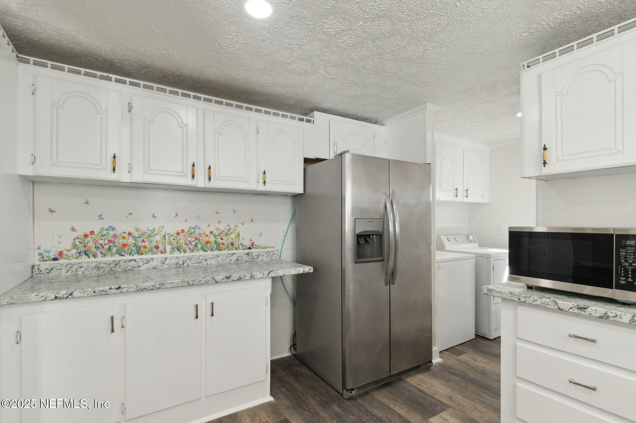 97119 Diamond Street Yulee, FL 32097 - Photo 21 of 42 a kitchen with granite countertop white cabinets and stainless steel appliances