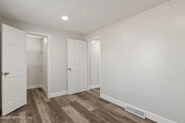 a view of hallway with closet and wooden floor
