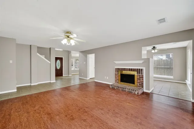 an empty room with windows and a fireplace