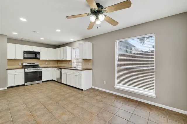a kitchen with stainless steel appliances granite countertop a stove a sink and a refrigerator