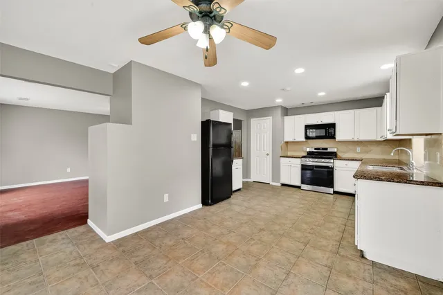 a kitchen with stainless steel appliances granite countertop a refrigerator and a stove top oven