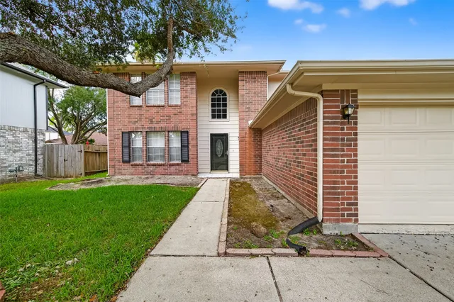 a view of brick house with a yard
