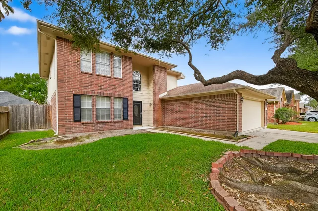 a front view of a house with a garden and yard