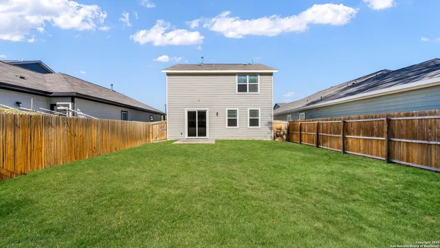 a view of a backyard with potted plants and large trees