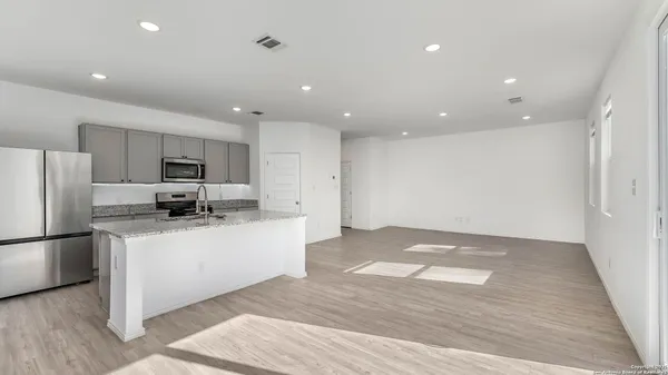 a kitchen with stainless steel appliances granite countertop a refrigerator and a stove top oven