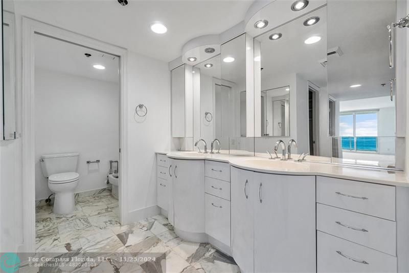 350 South Ocean Boulevard, Unit 5D Boca Raton, FL 33432 - Photo 16 of 35 a bathroom with a double vanity sink toilet and shower