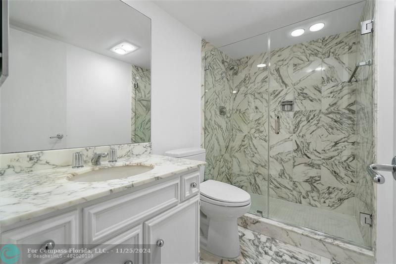 350 South Ocean Boulevard, Unit 5D Boca Raton, FL 33432 - Photo 19 of 35 a bathroom with a granite countertop sink a toilet and a shower