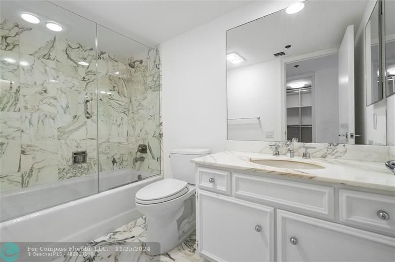 350 South Ocean Boulevard, Unit 5D Boca Raton, FL 33432 - Photo 21 of 35 a bathroom with a granite countertop sink a toilet and bathtub