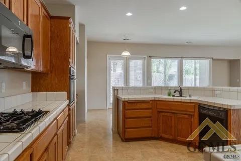 Undisclosed Address Bakersfield, CA 93311 - Photo 11 of 23 a kitchen with a sink stove and cabinets