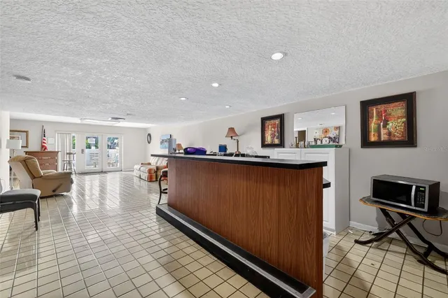 a living room with furniture a flat screen tv and kitchen view