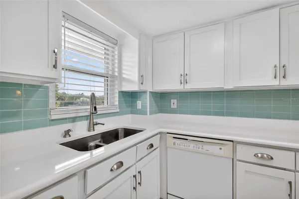 a kitchen with white cabinets and a sink
