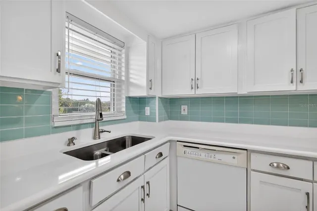 a kitchen with white cabinets and a sink