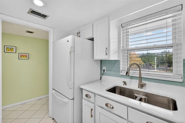 a kitchen with a sink a refrigerator and window