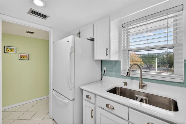 a kitchen with a sink a refrigerator and window