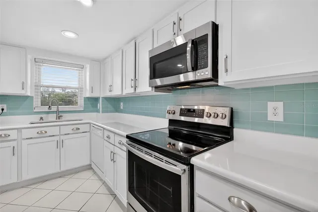 a kitchen with cabinets stainless steel appliances and a sink