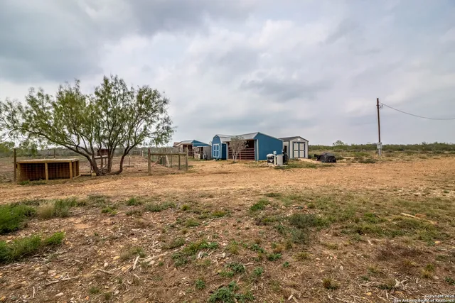 a view of a room with wooden floor and kitchen