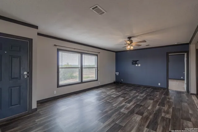 a view of an empty room with a kitchen
