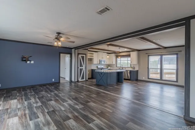 a kitchen with stainless steel appliances kitchen island granite countertop a sink stove and refrigerator