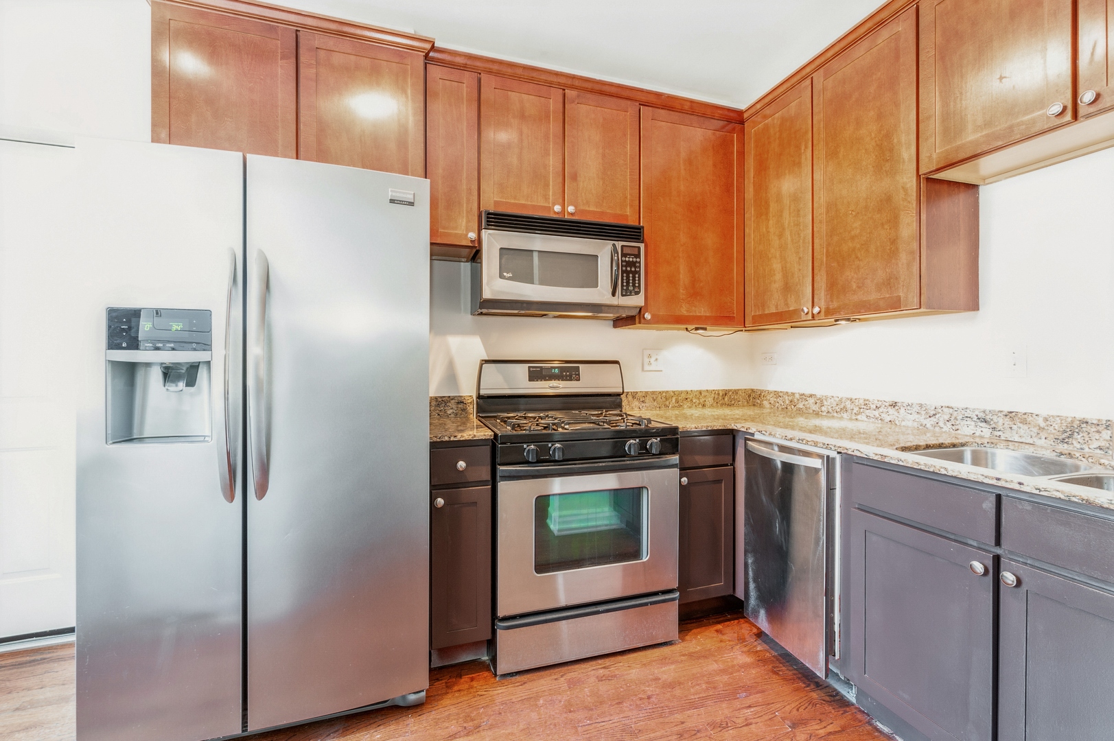 5743 North Ridge Avenue, Unit 1 Chicago, IL 60660 - Photo 5 of 12 a kitchen with granite countertop a refrigerator stove and microwave