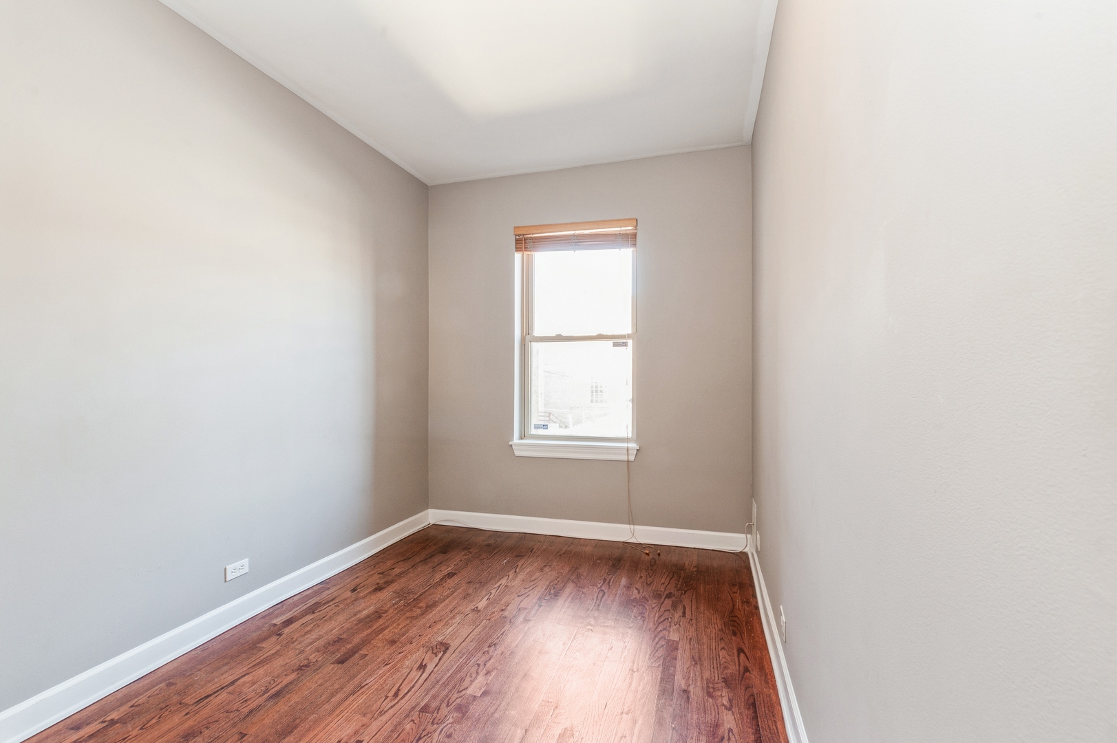 5743 North Ridge Avenue, Unit 1 Chicago, IL 60660 - Photo 8 of 12 an empty room with wooden floor and windows