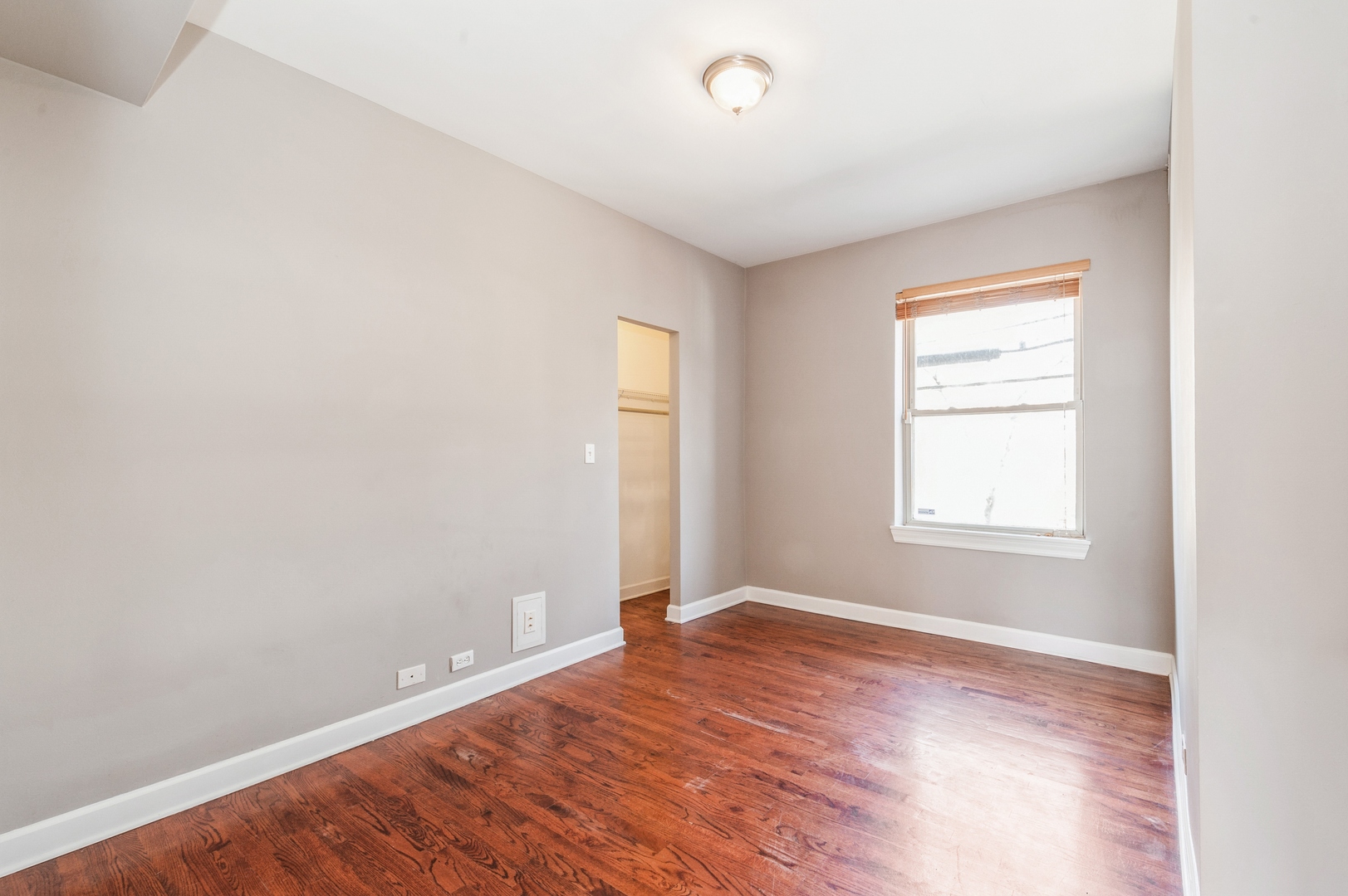 5743 North Ridge Avenue, Unit 1 Chicago, IL 60660 - Photo 9 of 12 an empty room with wooden floor and windows